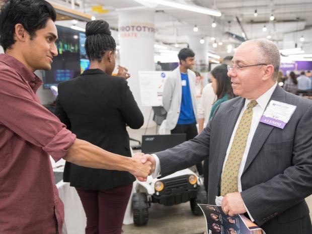 student shaking hand with an alum